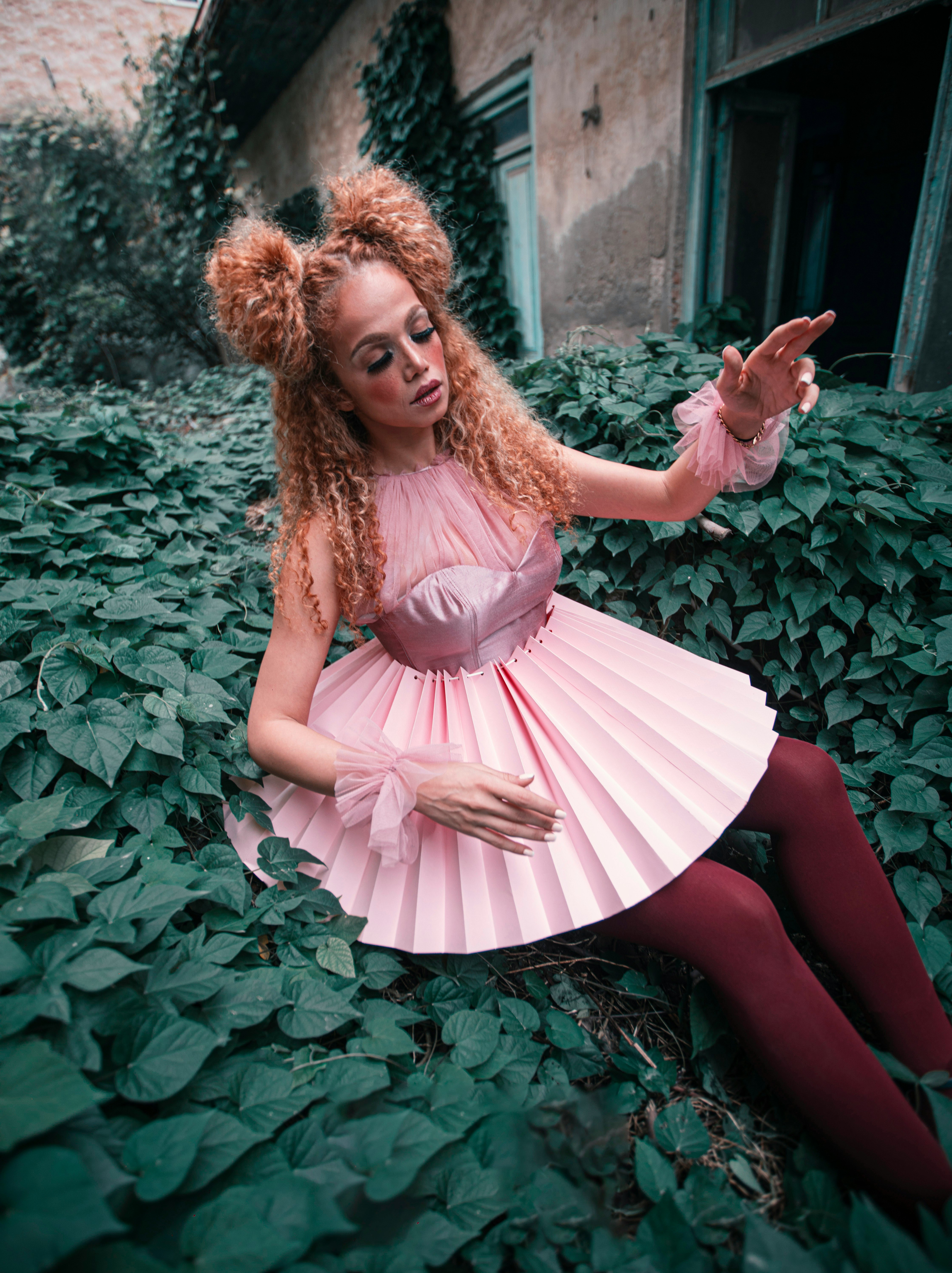 woman in pink dress lying on green grass